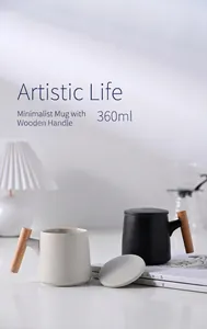 Detail showing two matte ceramic mugs with minimalist wooden handles and matching lids