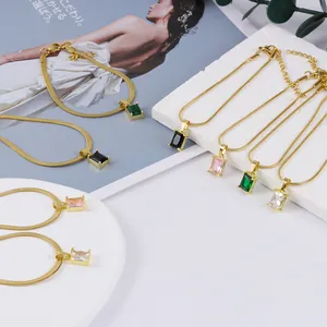 Primer plano de collares de cadena de serpiente dorada con colgantes de cristal rectangulares.