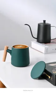 Close-up of minimalist dark green matte ceramic mug with a natural wooden handle.