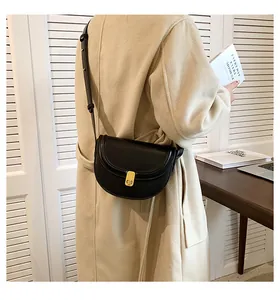 Minimalist retro black saddle crossbody bag for women, elegant lifestyle detail view