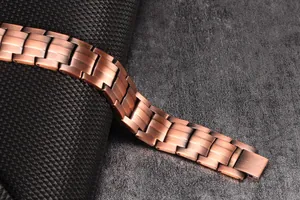 Close-up of vintage red copper magnetic bracelet with textured metallic links.