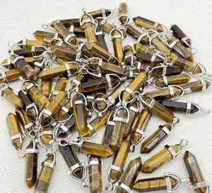Detailed macro view showing a pile of natural tiger eye crystal hexagonal column pendants.