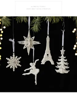 Close-up of white glittery Christmas tree ornaments in snowflake and star shapes