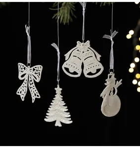 Detailed view of white glitter Christmas ornaments including bow, tree, bells, and snowman.