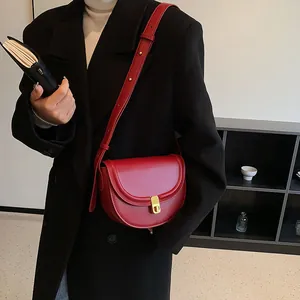 Vintage red leather saddle crossbody bag for women with minimalist gold clasp detail