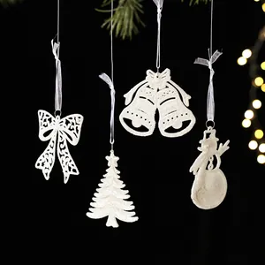 Sparkly white Christmas ornaments set with tree, bow, bells, and snowman designs