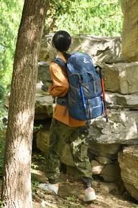 Outdoor view of an Asian model wearing a blue 50L Free Knight hiking backpack