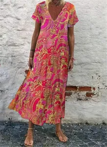 Detailed view of a woman wearing a vibrant pink V-neck paisley print maxi dress