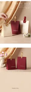 Detail view of elegant handheld candy bags in burgundy and cream with gold handle