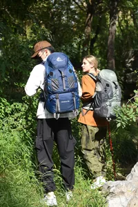 Close-up detail of hikers wearing Free Knight 60L outdoor adventure backpacks in a forest