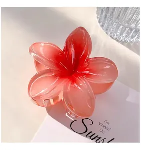 Close-up of a red gradient plumeria flower hair claw clip with a glossy finish.