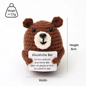 Handmade brown crochet bear holding a positive message card for stress relief