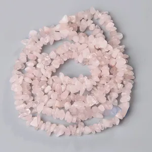 Detaillierte Makroaufnahme von natürlich polierten rosa Rosenquarz-Chips für DIY-Schmuck