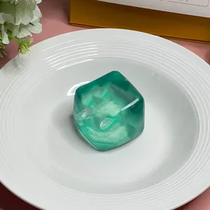 Detail showing a translucent green maltose squishy toy shaped like a large ice cube