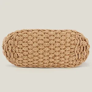 Hand-woven straw handbag bottom detail showing tight knit texture and oval base shape.