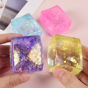 Close-up of vibrant glitter-filled ice cube squishy stress relief toys in hands.