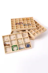 Detailed view of solid wood multi-grid jewelry organizer trays with ring and watch