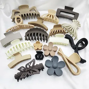 Assorted matte hair claws in neutral colors including flower and butterfly shapes