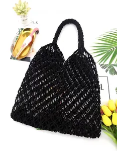 Detailed view of black hand-woven cotton rope mesh shoulder bag for vacation