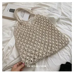 Detail view of a white handmade macrame woven bag with hollow out cotton rope.