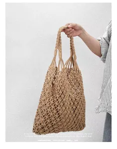 Detail of hand-woven cotton rope mesh bag with braided handle for beach vacation