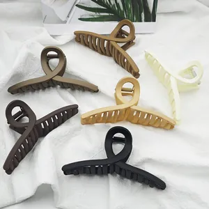 Detailed view of matte finish shark hair claw clips in assorted earth tone colors