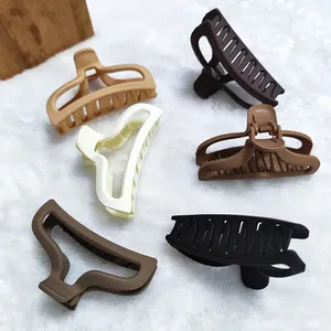 Close-up detail of variety matte large hair claw clips set in elegant earthy colors