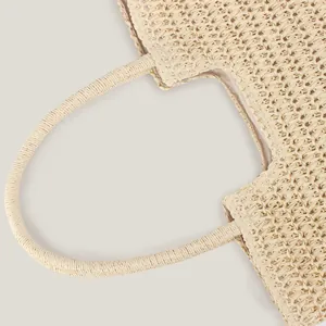 Detailed macro shot of a retro woven straw shoulder bag featuring a sturdy handle