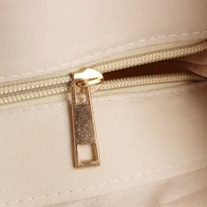 Close-up of the smooth golden metal zipper detail on a retro woven straw shoulder bag