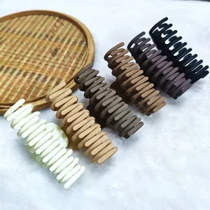 Set of six minimalist matte hair claw clips in neutral earth tones on plush background