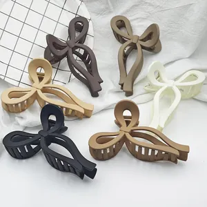 Six large bow-shaped matte hair claw clips in assorted neutral Morandi colors for women