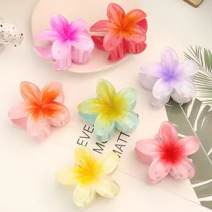 Macro view of colorful plumeria flower hair claws with a translucent gradient finish