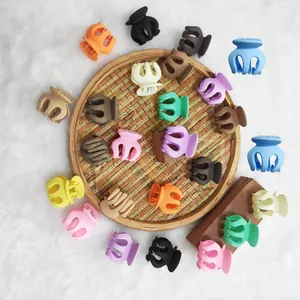 Close-up of matte hair claw clips in various colors arranged on a bamboo tray