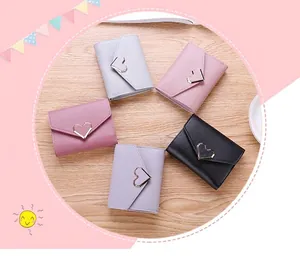 Detail of five multi-colored tri-fold wallets with heart-shaped metal clasps