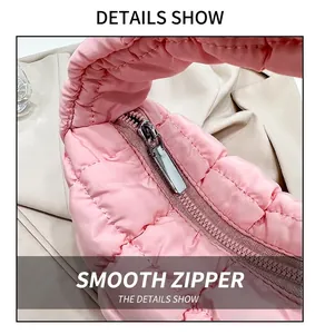 Close-up detail of the smooth metal zipper on a pink quilted puffer cloud bag handle.