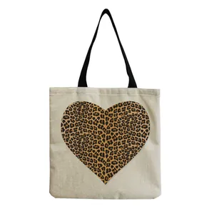 Detailed close-up showing the heart-shaped leopard print on beige canvas tote bag