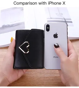 Detailed size comparison of a black trifold heart wallet next to a smartphone device