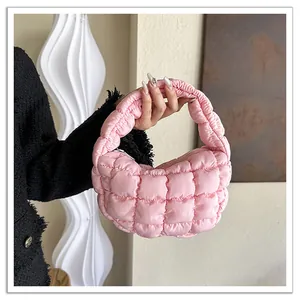 Detail view of pink quilted puffer cloud bag with soft padded handle and grid pattern.