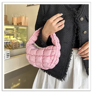 Detail view of a pink quilted mini cloud bag with pleated grid texture and puffy cotton filling