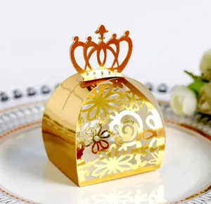 Elegant golden crown shaped laser cut wedding favor candy box displayed on a plate