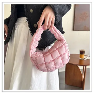 Close-up detail of a pink quilted puffer cloud bag with soft padded texture and handle
