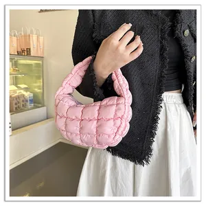 Detail view of a pink quilted cloud handbag with soft down-filled padding and hobo style