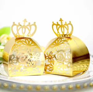 Detailed view of two laser-cut golden crown candy boxes with elegant floral hollow design