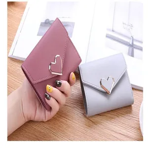 Detail of women's tri-fold wallet with elegant metal heart buckle design
