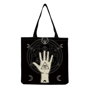 Detailed view of black canvas tote bag featuring occult hand and eye pattern print