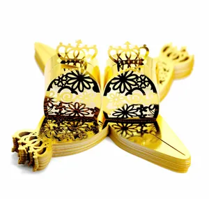 Close-up of golden laser-cut wedding favor boxes with intricate hollow patterns