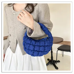Close-up detail of a stylish blue quilted cloud handbag featuring soft pleated grid texture.