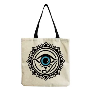 Close-up detail of a stylish linen tote bag featuring a bold blue eye graphic print