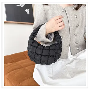 Detailed view of black quilted cloud bag with pleated grid texture and padded filling