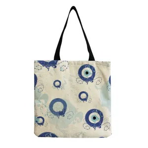Detail of the linen-textured fabric and blue Evil Eye pattern on the shoulder bag.